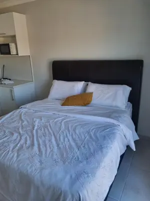 a bed with a black headboard and white pillows at 5 AntiP in Cape Town