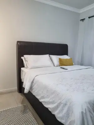 a bed with a black frame and white sheets and pillows at 5 AntiP in Cape Town