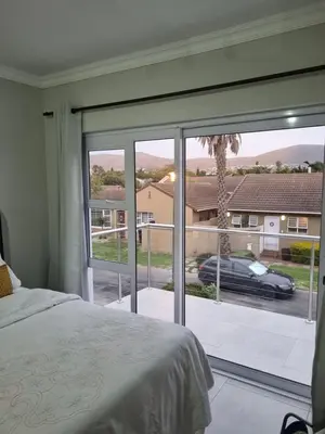 a bedroom with a large window with a view of a car at 5 AntiP in Cape Town