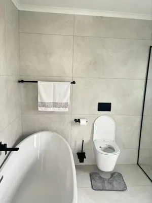 a bathroom with a white tub and a toilet at 5 AntiP in Cape Town