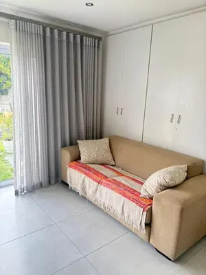 a couch sitting in a room with a window at 5 AntiP in Cape Town