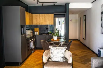a kitchen with a table and chairs in a room at KML Nine Palms luxury 101 in Cape Town