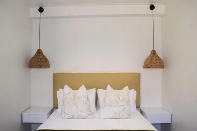 a bedroom with a bed with white sheets and pillows at House on Pringle in Cape Town