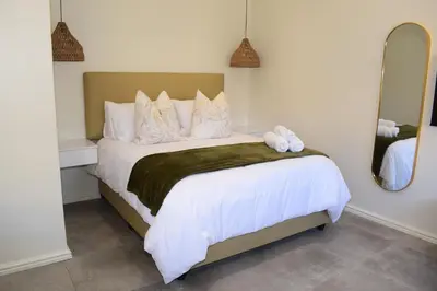a bedroom with a bed with two stuffed animals on it at House on Pringle in Cape Town