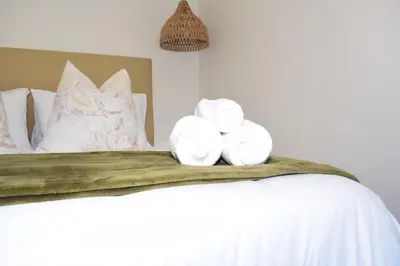 a bed with towels and pillows on it at House on Pringle in Cape Town