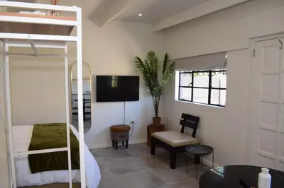 a living room with a bunk bed and a desk at House on Pringle in Cape Town