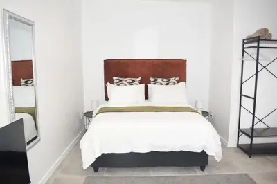 a bedroom with a large bed with a wooden headboard at House on Pringle in Cape Town