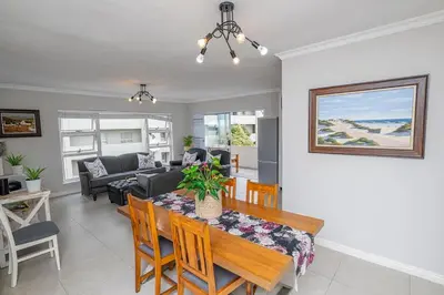 a dining room and living room with a table and chairs at Island view on Clam in Cape Town