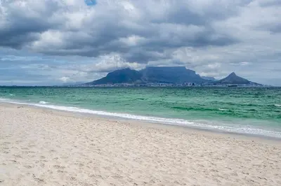 a beach with a view of the ocean and a mountain at Island view on Clam in Cape Town