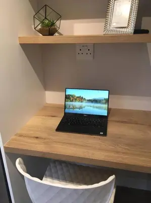 a laptop computer sitting on top of a wooden desk at Lovely studio apartment in Pinelands, Cape Town in Cape Town