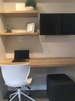 an office with a desk with a laptop and a chair at Lovely studio apartment in Pinelands, Cape Town in Cape Town