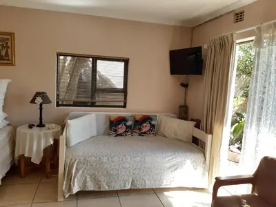 a bedroom with a bed with two pillows on it at Cosy studio garden cottage in Cape Town