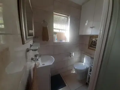 a bathroom with a sink and a toilet at Cosy studio garden cottage in Cape Town