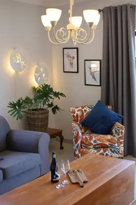 a living room with a table and a couch at At Hummingbird Hill Hermanus in Hermanus