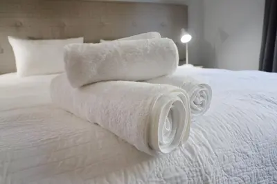 a pile of towels sitting on top of a bed at At Hummingbird Hill Hermanus in Hermanus