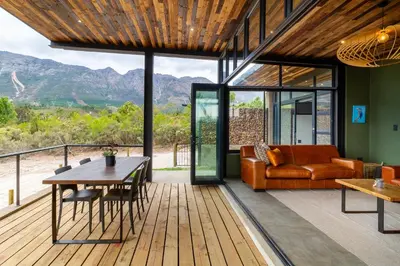 a living room with a couch and a table at Steenbok farm cottages Kingfisher Cottage in Wolseley