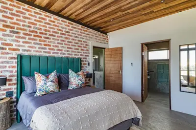 a bedroom with a brick wall and a bed at Steenbok farm cottages Kingfisher Cottage in Wolseley