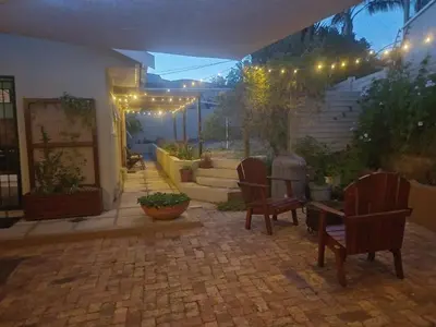 a patio with chairs and a staircase with lights at Strandloper Room in Cape Town