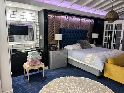 a bedroom with a bed and a desk and a tv at Apartment on 32 in Cape Town