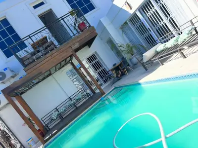 a swimming pool in front of a building at Apartment on 32 in Cape Town