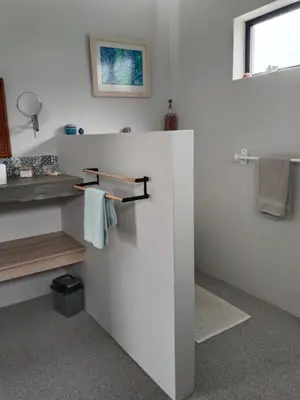 a bathroom with white walls and a sink and towels at Prinia on Peak holiday home in Pringle Bay