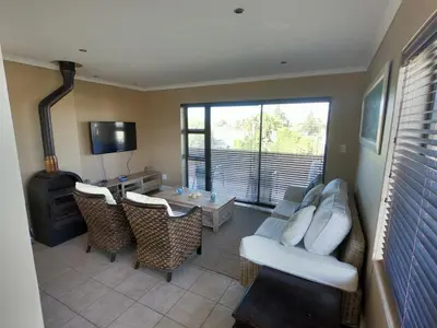 a living room with a couch and chairs and a fireplace at Blue Mountain View in Cape Town