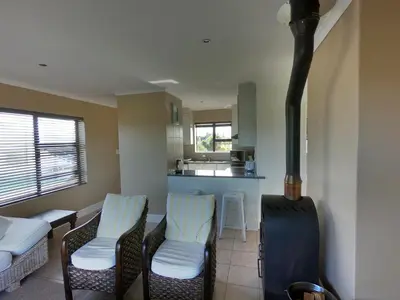 a living room with a stove and chairs and a kitchen at Blue Mountain View in Cape Town
