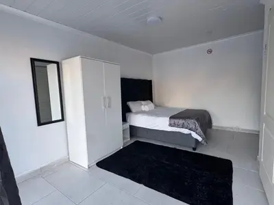 a small bedroom with a bed and a cabinet at No 1 Guest house in Cape Town