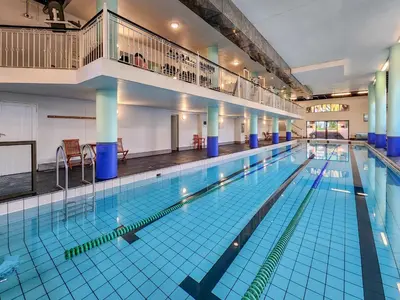 a large swimming pool in a large building at Peaceful Retreat, Pools, Gym, Parks in Cape Town
