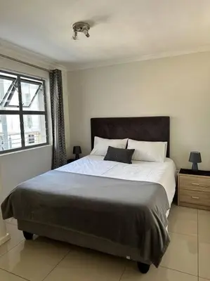 a bedroom with a large bed and a window at Cozy Rondebosch Apartment in Cape Town