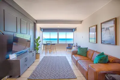 a living room with a couch and a flat screen tv at Isla's Place (Strandsig 304) in Cape Town