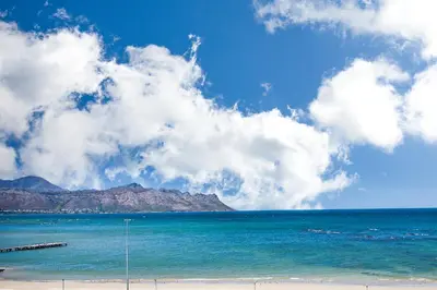 a view of the ocean with mountains in the background at Isla's Place (Strandsig 304) in Cape Town