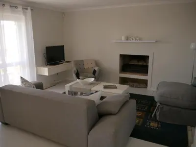 a living room with a couch and a tv at Die Steenhuisie in Pringle Bay