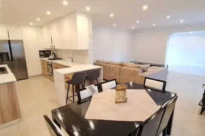 a kitchen and living room with a table and chairs at Villa Lamsyh- your second home in Cape Town