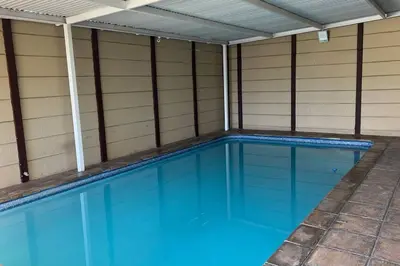 a swimming pool with blue water in a house at Bosch Villa in Cape Town
