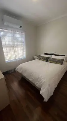 a bedroom with a white bed and a window at Bosch Villa in Cape Town
