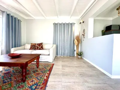 a living room with a couch and a table at Brunia Bay Apartment in Hermanus