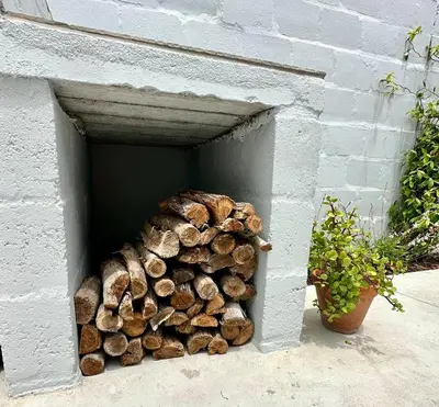 a pile of fire wood in a wall at Brunia Bay Apartment in Hermanus