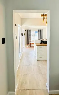 a hallway of a home with a kitchen and flooring at Brunia Bay Apartment in Hermanus