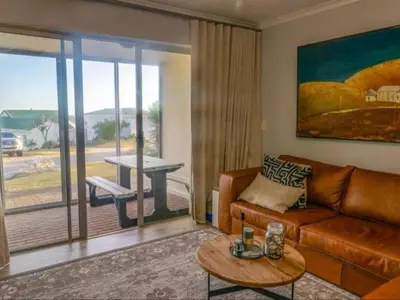a living room with a couch and a table at Refresh at 50 Whale Rock in Hermanus