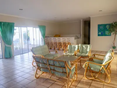 a living room with chairs and a table at Refresh at 50 Whale Rock in Hermanus