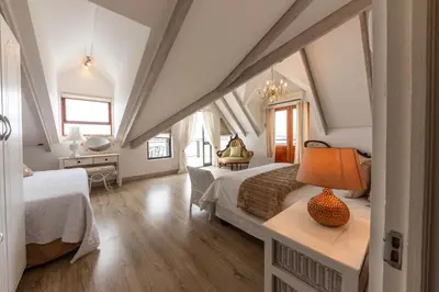 a bedroom with two beds and a table with a lamp at 'Seagul Cove', Private Villa on the beach, Sleeps 7 in Cape Town
