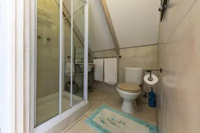 a small bathroom with a toilet and a shower at 'Seagul Cove', Private Villa on the beach, Sleeps 7 in Cape Town