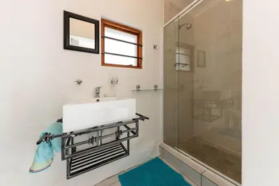 a bathroom with a sink and a shower at 'Seagul Cove', Private Villa on the beach, Sleeps 7 in Cape Town