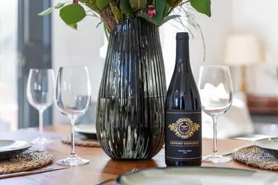 a bottle of wine sitting on a table with glasses at Cosy Home in Claremont in Cape Town