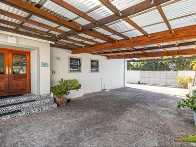 a garage with a wooden door and a wooden ceiling at Hermanus Cliff Path Lodge - No Load-shedding in Hermanus