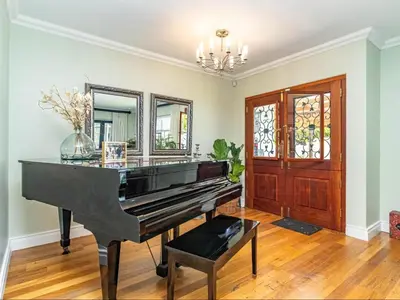 a piano in a living room with a mirror at Hermanus Cliff Path Lodge - No Load-shedding in Hermanus