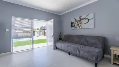 a living room with a couch and a sliding glass door at Inkantu Apartments & Suites in Cape Town