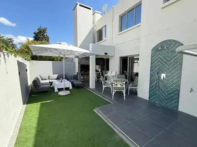 a patio with an umbrella and a table and chairs at La Gratitude 8 luxury in Stellenbosch CENTRAL in Stellenbosch