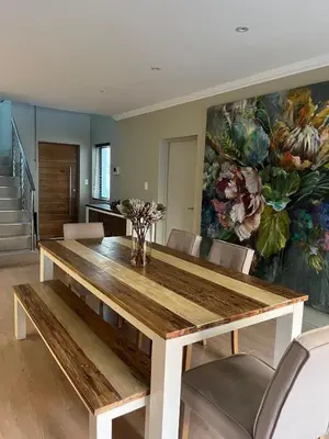 a dining room table with chairs and a painting at La Gratitude 8 luxury in Stellenbosch CENTRAL in Stellenbosch